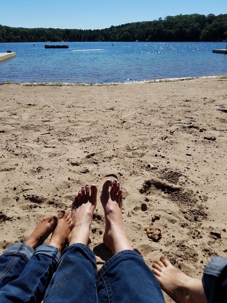 Beth Mattson and kids splay toes on the beach of Pine Lake